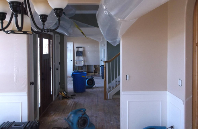 floor water damage restoration with blue air mover equipment