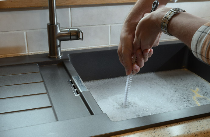 A man trying to clean overflowed kitchen sink